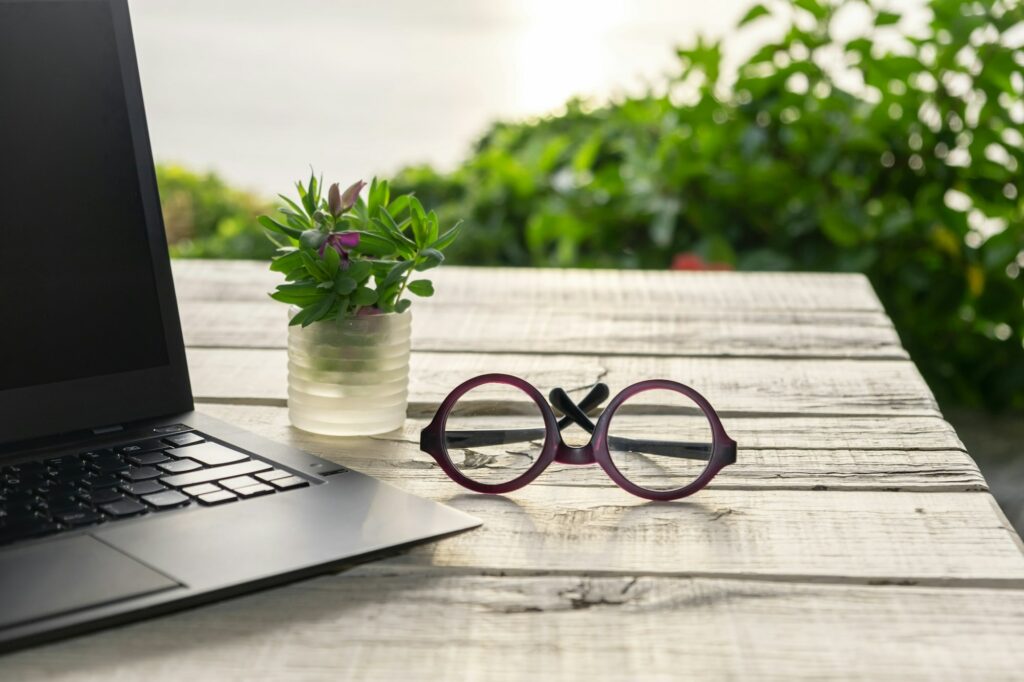 Laptop on the garden table, green nature background