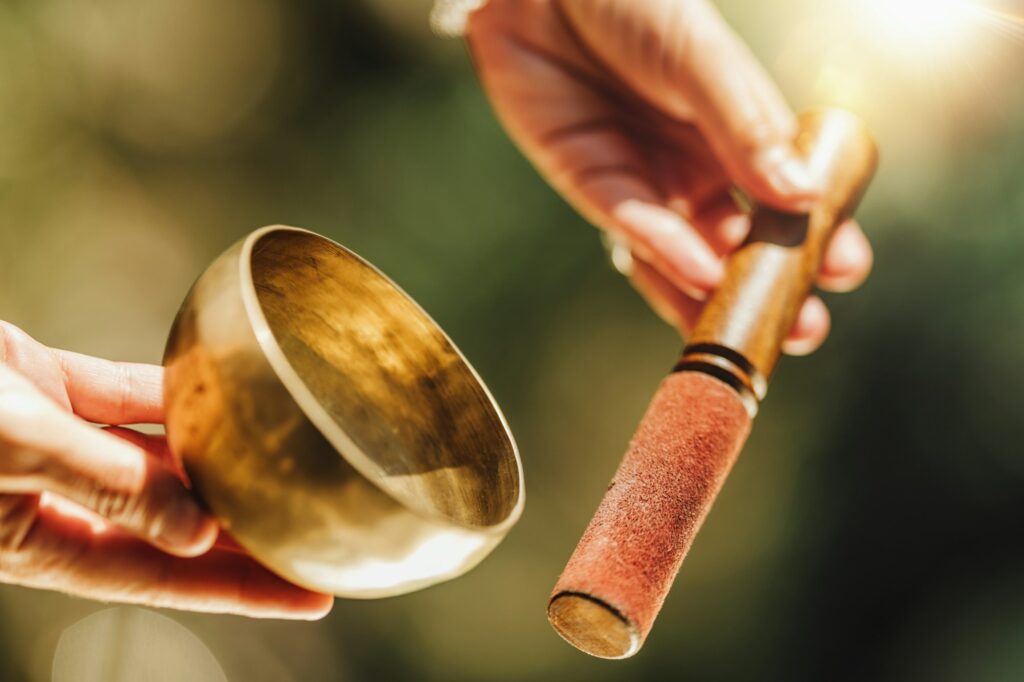 Hands of a Woman Playing Tibetan Singing Bowl in Nature